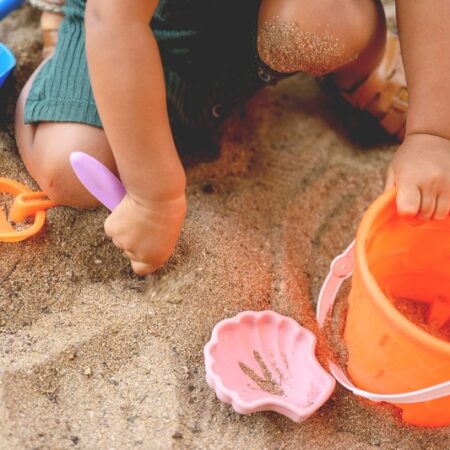 Low section of child playing in the sand, copy space, Nikon Z7